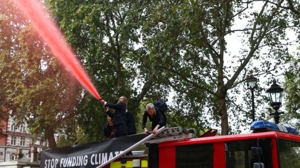 
                              Extinction Rebellion protesters use fire engine to spray Treasury with fake blood
                      